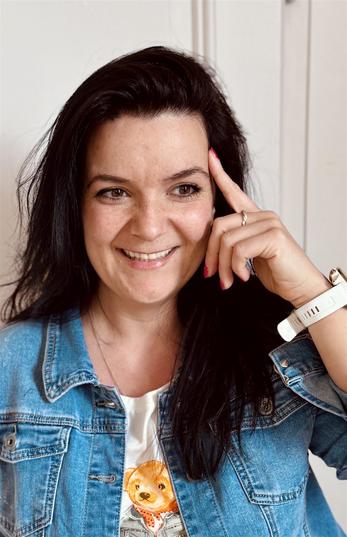 Neda Hundertmark lacht in die Kamera, den Finger an der Schläfe – vom Kopf ins Handeln